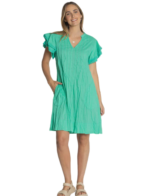 Woman wearing a green dress against a plain background