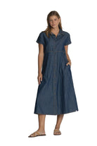 Woman wearing a blue denim dress against a plain background