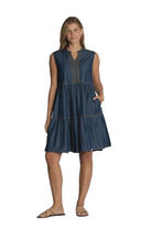 Woman wearing a blue dress against a plain background