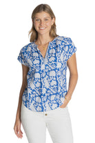 Woman wearing a blue floral blouse against a plain background