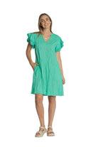 Woman wearing a green dress against a plain background