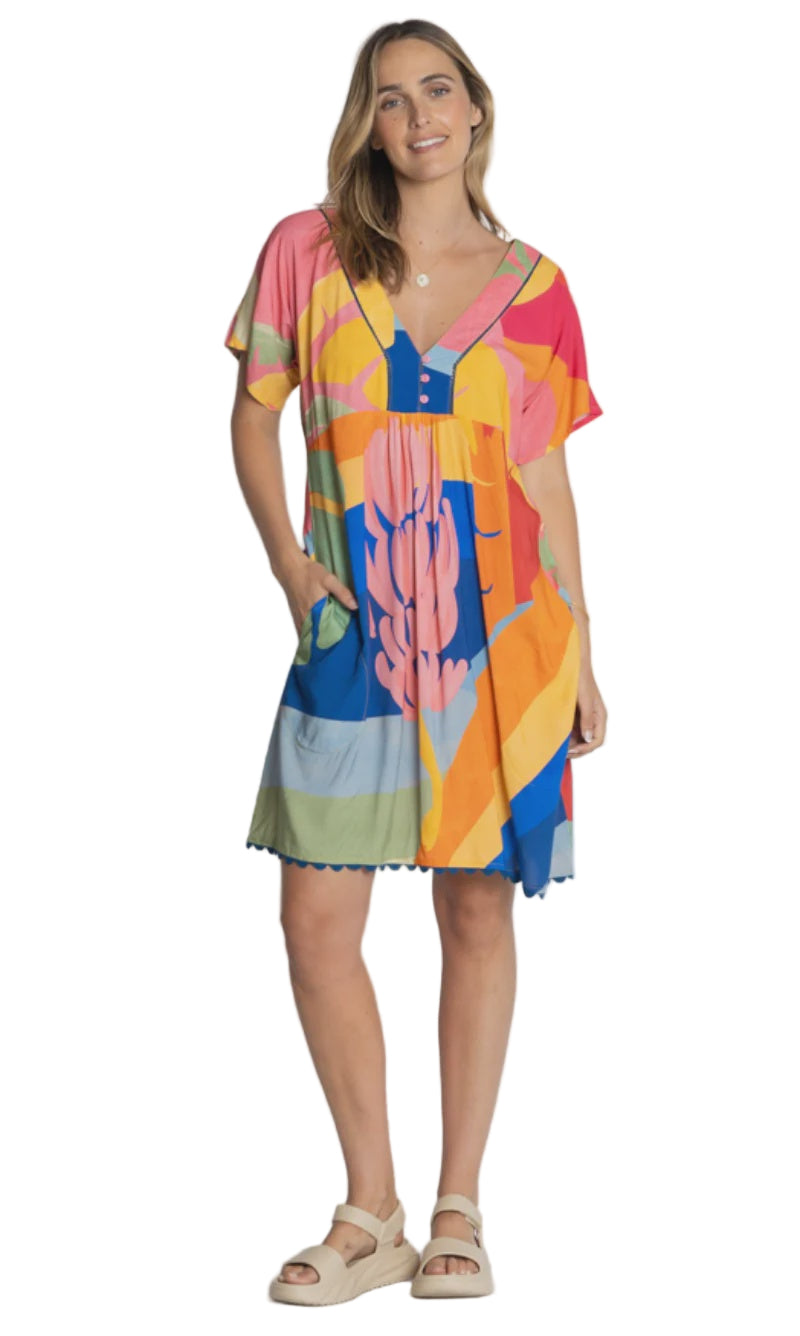 Woman wearing a colorful dress with abstract patterns on a plain background